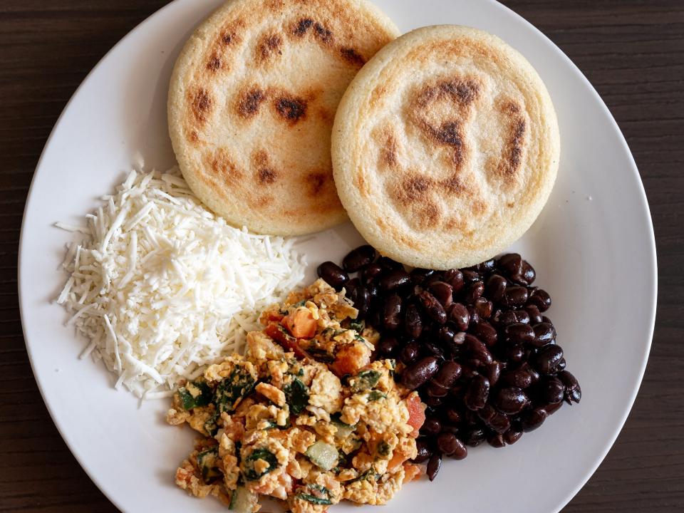 Venezuelan breakfast with arepas, black beans, scrambled eggs and white cheese.