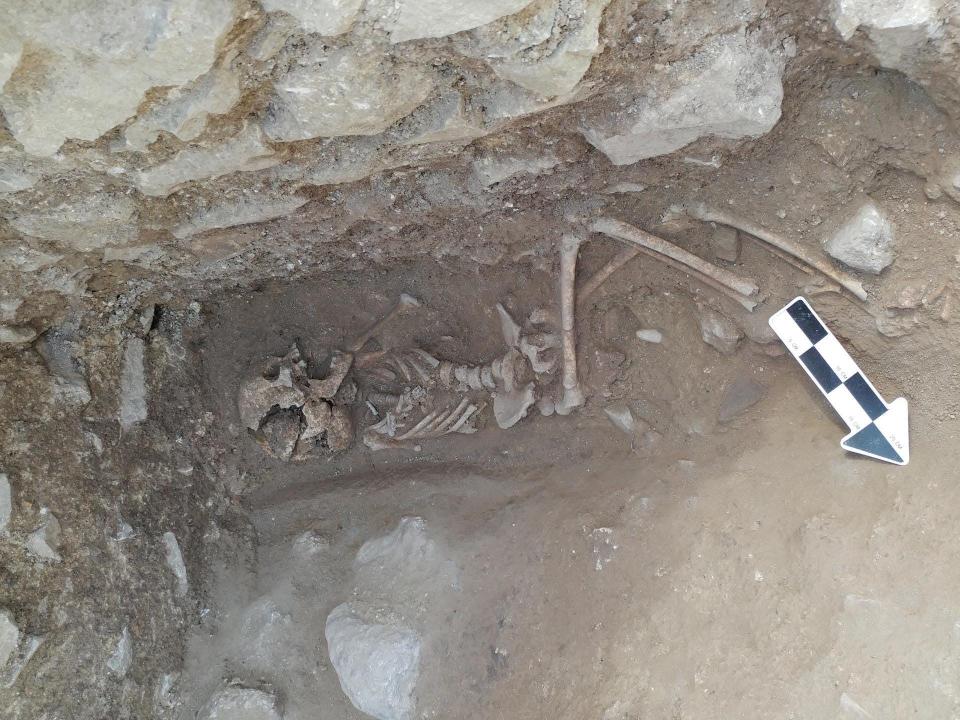 Remains of a ten year old child buried in a Roman cemetary in the 5th century with a stone in the mouth are shown here.