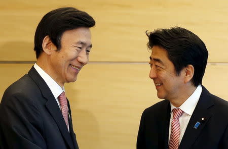 South Korea's Foreign Minister Yun Byung-se (L) talks with Japan's Prime Minister Shinzo Abe at the start of their talks at Abe's official residence in Tokyo June 22, 2015. REUTERS/Issei Kato