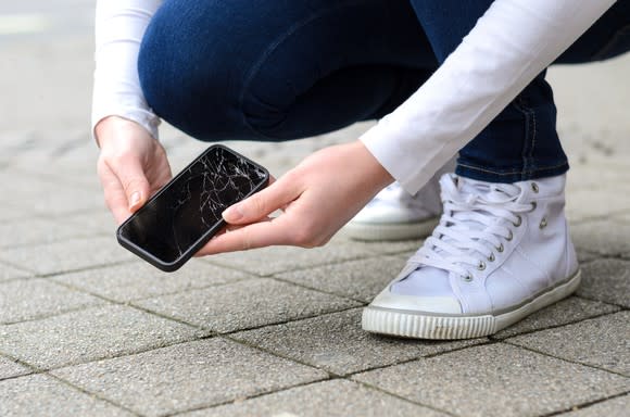 Person holding a cracked phone after dropping it