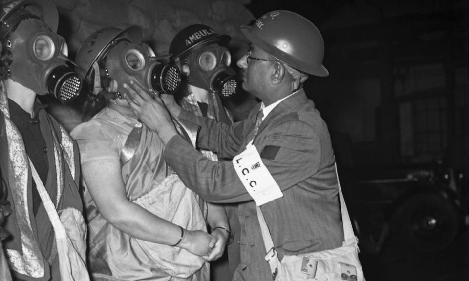 A group of Indian women who have volunteered to man the auxiliary ambulance station in Augustus Street, St Pancras, London, undergoing a gas mask drill, 23 December 1939.