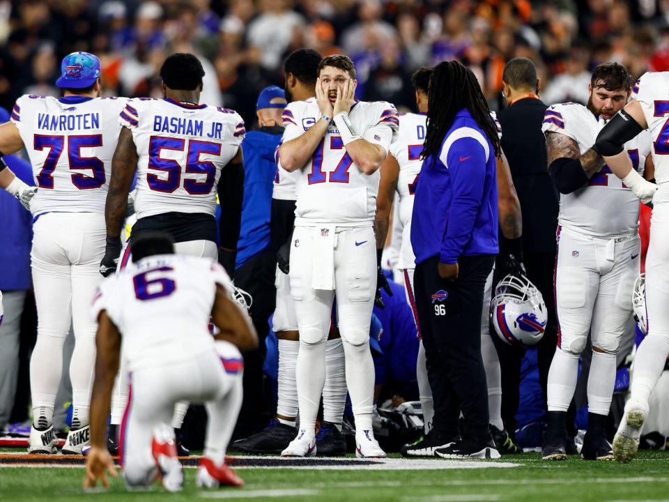 Bills players stand on the field as Damar Hamlin is given CPR.