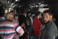 People line up outside an exchange shop to buy U.S. dollars, in Beirut, Lebanon, June 17, 2020. Lebanon's financial meltdown has thrown its people into a frantic search for dollars as the local currency's value evaporates. Long, raucous lines mass outside exchange bureaus to buy rationed dollars. With tens of thousands thrown into poverty, the turmoil is fueling bitterness at banks and politicians. (AP Photo/Hussein Malla)