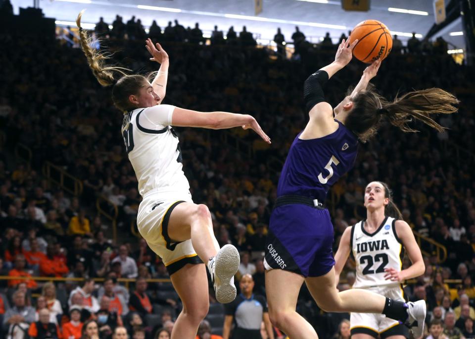 Iowa's Kate Martin defends a shot by Holy Cross' Kaitlyn Flanagan, right, during an NCAA Tournament first-round game Saturday.