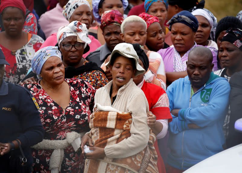 A family member is consoled at the scene of a deadly mass shooting near Pietermaritzburg