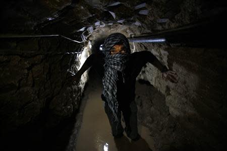 A Palestinian works inside a smuggling tunnel flooded by Egyptian forces, beneath the Egyptian-Gaza border in Rafah, in the southern Gaza Strip in this February 19, 2013 file photo. REUTERS/Ibraheem Abu Mustafa/Files