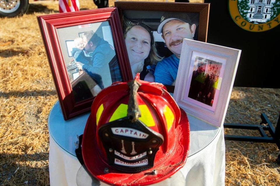 Photos and a fire helmet belonging to Cal Fire Capt. Paul Rotondaro are displayed during a ceremony dedicating a section of Highway 140 near Gustine, the Paul Vincent Rotondaro Memorial Highway in Merced County, Calif., on Monday, Sept. 18, 2023. Rotondaro was killed in a head-on traffic collision while on duty with Cal Fire in Merced County on Oct. 2, 2019.