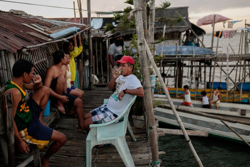 The Wider Image: Rising seas threaten early end for sinking village in Philippines