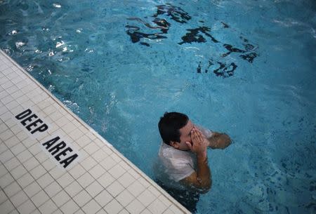 Raul Contreras, 19, of Honduras, who is seeking refugee status in Canada, works out at the pool of a long-stay hotel in Toronto, Ontario, Canada April 9, 2017. REUTERS/Chris Helgren