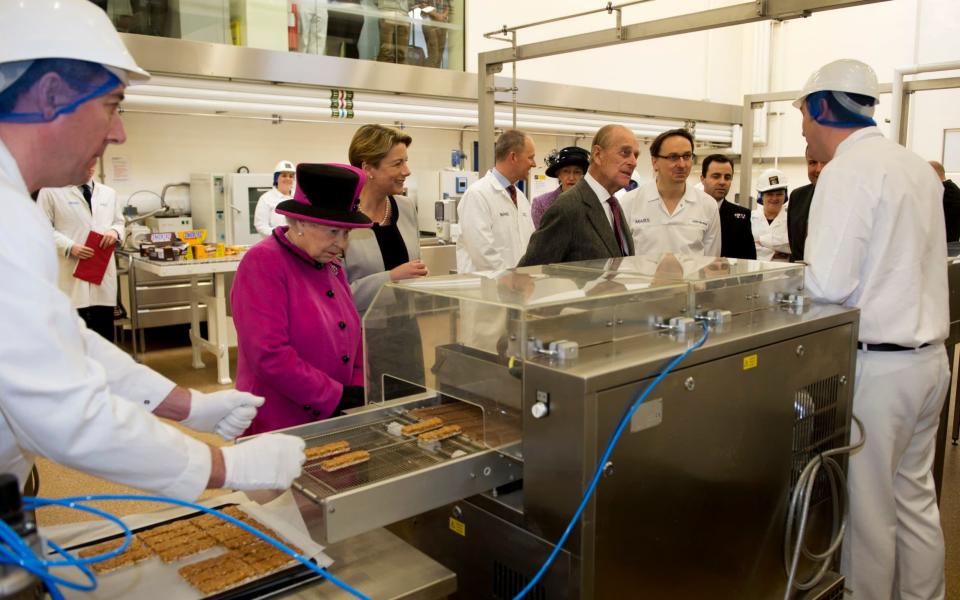 Queen Elizabeth II and the Duke of Edinburgh during a visit to Mars Chocolate UK in Slough - Credit: AFP