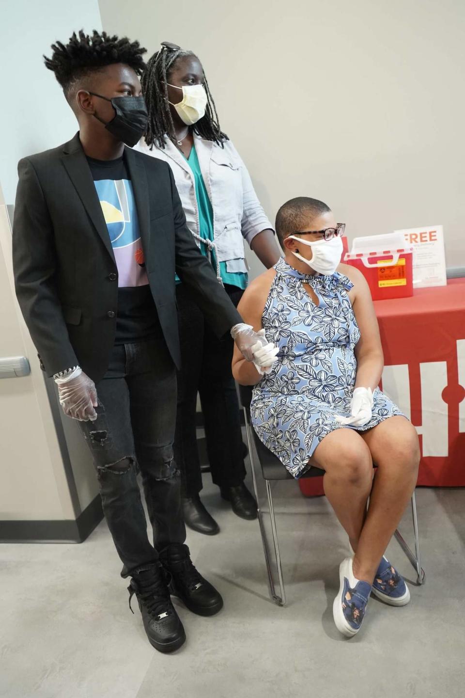 Sheletta Brundidge held her son Andrew's hand as she got the COVID-19 vaccine.