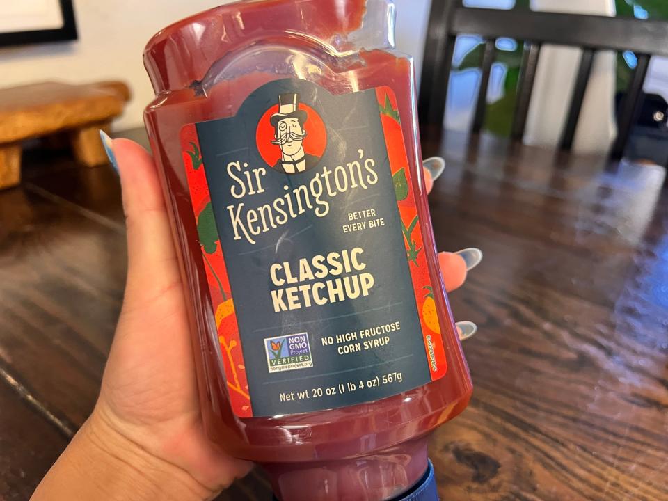 Hand holding bottle of sir kensington's ketchup