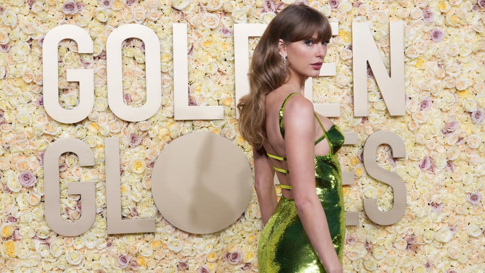 Taylor Swift wore a sleek green Gucci dress and De Beers jewelry. - Jordan Strauss/Invision/AP