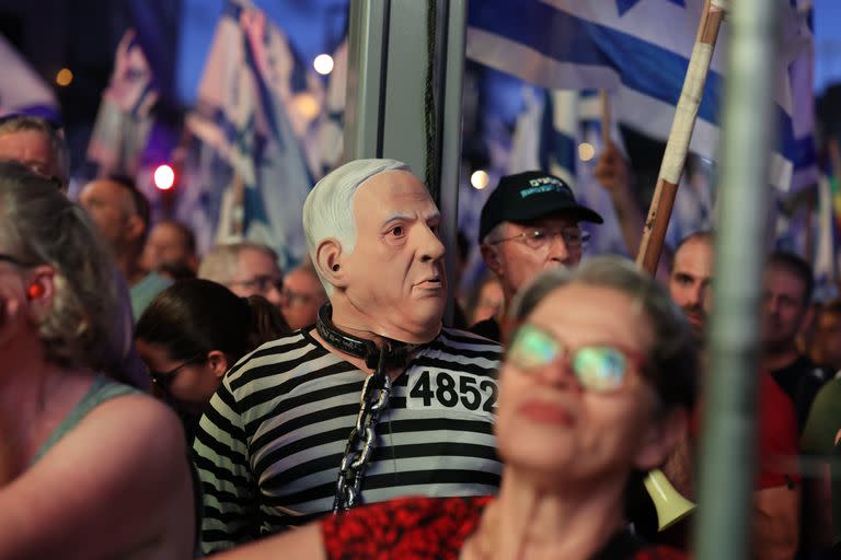Un manifestante de este sábado luce una máscara de Netanyahu con ropa de presidiario. Photo: Ilia Yefimovich/dpa