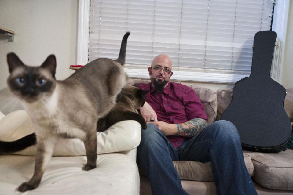 This undated photo provided by the Animal Planet shows cat behaviorist Jackson Galaxy host of the Animal Planet television show "My Cat from Hell" with Sully and Lulu in the Sherman Oaks area of Los Angeles. Cats don't turn on their families for no reason, says Galaxy. He's worried about Internet hysteria that 's been building since March 7, 2014, when an Oregon family called 911 to report that Lux the cat had them trapped in a bedroom and they couldn't get out. (AP Photo/John Chapple, Animal Planet)