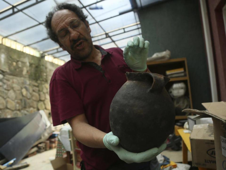 Jedu Sadarnaga shows pottery on November 15, 2018 from one of the tombs found at a Bolivian quarry near the capital of La Paz. The tombs contained remains belonging to more than 100 individuals and were buried with more than 30 vessels used by the Incas. (AP/Luis Gandarillas)