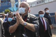 Avanza Pais party presidential candidate Hernando De Soto, wearing a mask to curb the spread of the new coronavirus, waves to supporter upon his arrival to vote during general elections in Lima, Peru, Sunday, April 11, 2021. (AP Photo/Martin Mejia)