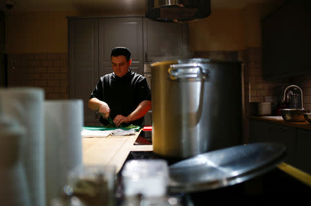 FILE PHOTO: A chef of Caffe Italia restaurant cooks soup as part of a charity program to help homeless people in St. Petersburg, Russia November 28, 2018. REUTERS/Anton Vaganov