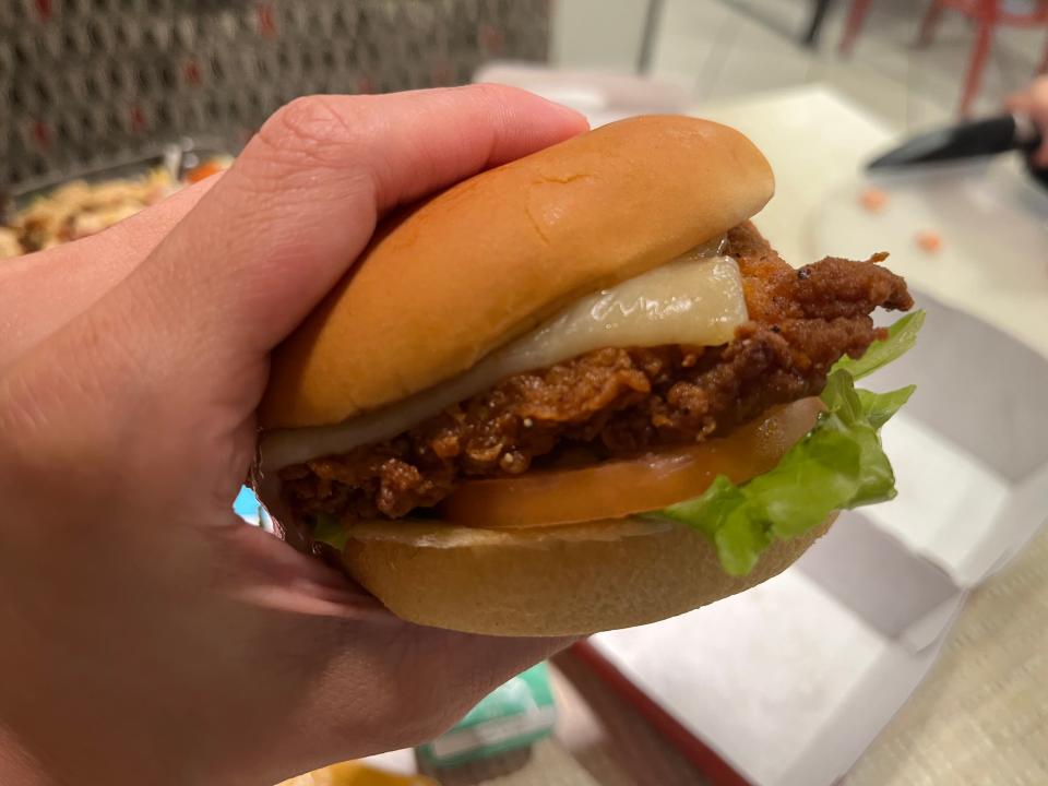 hand holding super deluxe chicken sandwich from chick fil a