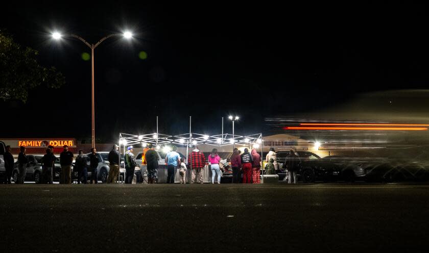 FONTANA, CA - DECEMBER 15, 2023: A crowd forms at a street vendors taco stand off Sierra Avenue on December 15, 2023 in Fontana, California.This street vendor is from Los Angeles. Recently, a food vendor had all her food tossed and equipment confiscated by code enforcement. The city of Fontana just passed an ordinance contracting a third-party company for $600,000 to patrol and impound street vendors' equipment that lack the required permit.(Gina Ferazzi / Los Angeles Times)