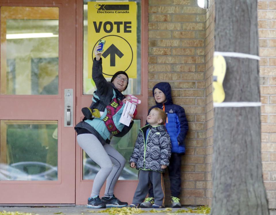 Alexandra Pettit takes a selfie with her kids at the Gloucester Presbyterian Church polling station, in Ottawa, after casting her vote in the Canadian federal election on Monday, Oct. 19, 2015. THE CANADIAN PRESS/ Patrick Doyle