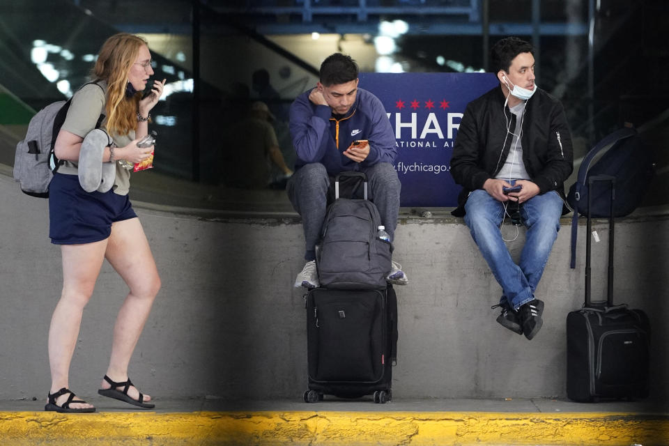 Travelers wait for public transportation at O'Hare International Airport in Chicago, Friday, July 2, 2021. AAA forecasts that more than 47 million people will travel by car or plane this weekend in the U.S., a return to 2019 levels and 40% higher than last year. (AP Photo/Nam Y. Huh)