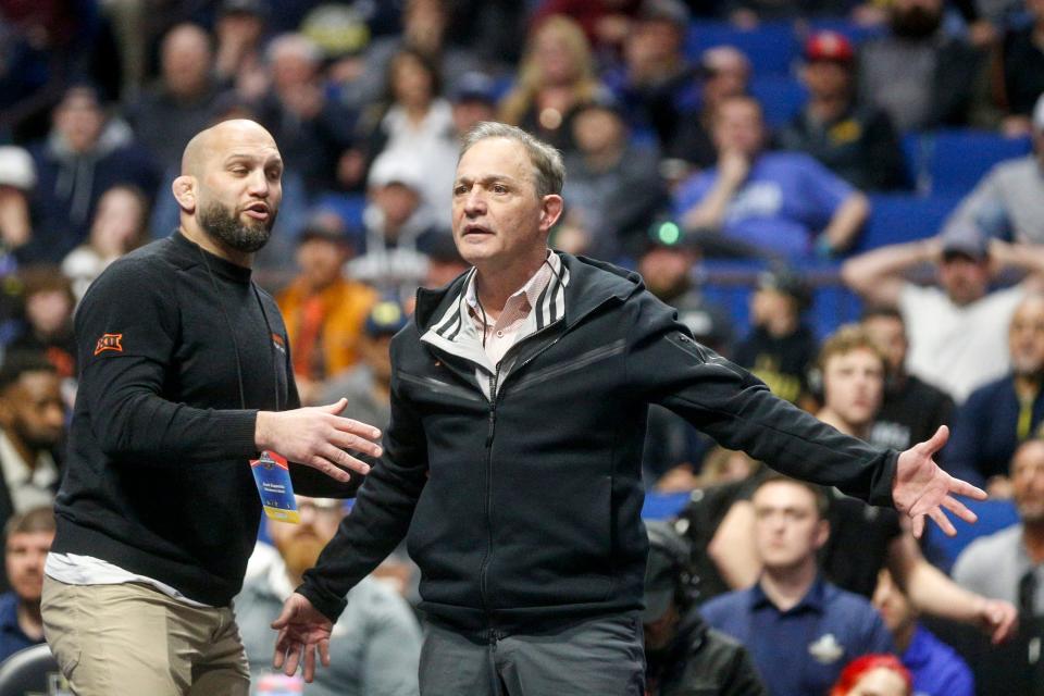 Oklahoma State assistant coach Zack Esposito holds back head coach John Smith as Smith reacts to a call by an official during the medal round of the NCAA Wrestling Championships 2023 at the BOK Center in Tulsa, Okla. on Saturday, March 18, 2023.