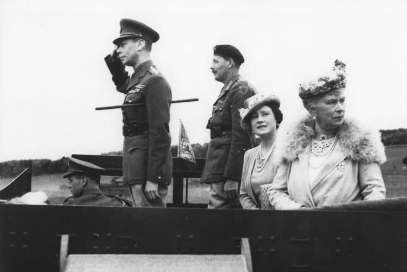 Britain's King George VI (L), on top of an armored vehicle, gives a salute as tanks of a Guards Armored Division pass during a demonstration in 1942. With him are his wife, Queen Elizabeth and his mother, Queen Mary (R). On May 12, 1937, George VI was crowned king of England, succeeding his brother Edward, who abdicated to marry U.S. divorcee Wallis Simpson. UPI File Photo