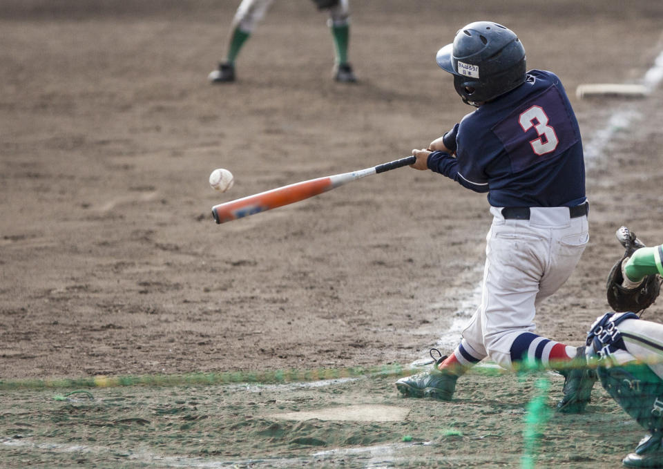 A young boy hitting a baseball.