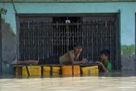 Residents use a makeshift raft as they make their way through floodwaters in Kalay, upper Myanmar's Sagaing region, on August 2, 2015