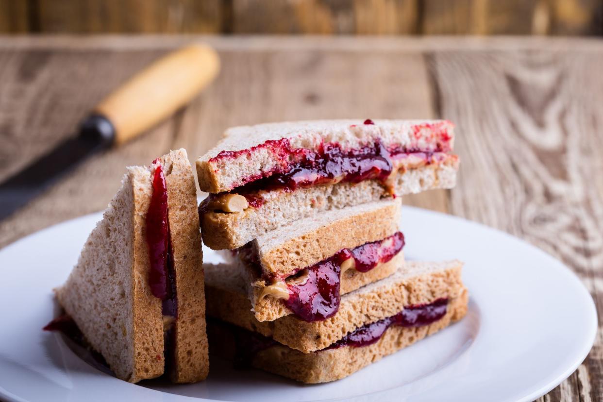 Peanut butter and jelly sandwich with whole wheat bread on rustic wooden table