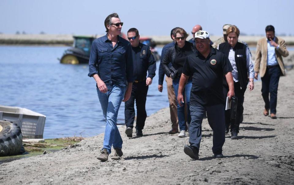 California Governor Gavin Newsom, far left, arrives to speak to the media at Hansen Ranches in a flooded area along 6th Avenue Tuesday afternoon, April 25, 2023, just south of Corcoran, CA.