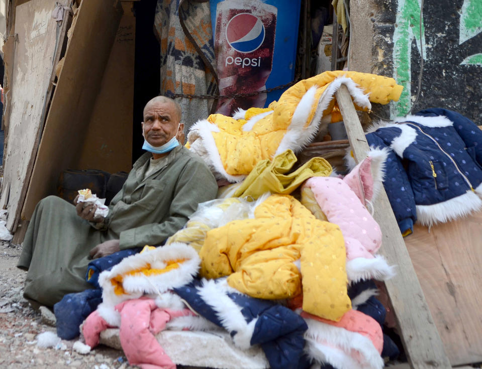 A man guards belongings of victims at the site of the collapsed apartment building in the el-Salam neighborhood, in Cairo, Egypt, Saturday, March 27, 2021. A nine-story apartment building collapsed in the Egyptian capital early Saturday, killing at several and injuring about two dozen others, an official said. (AP Photo/Tarek wajeh)