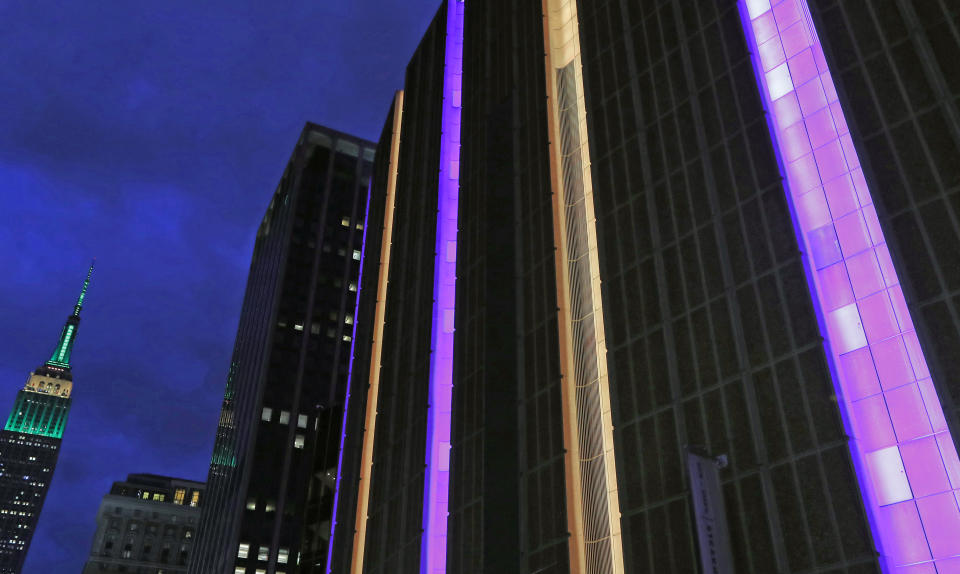 The exterior of Madison Square Garden, right, is lit in gold and purple, the Los Angeles Lakers colors, as the Empire State Building is at left, in the wake of the death of retired NBA star Kobe Bryant before the start of a basketball game between the Brooklyn Nets and the New York Knicks, Sunday, Jan. 26, 2020, in New York. (AP Photo/Kathy Willens)