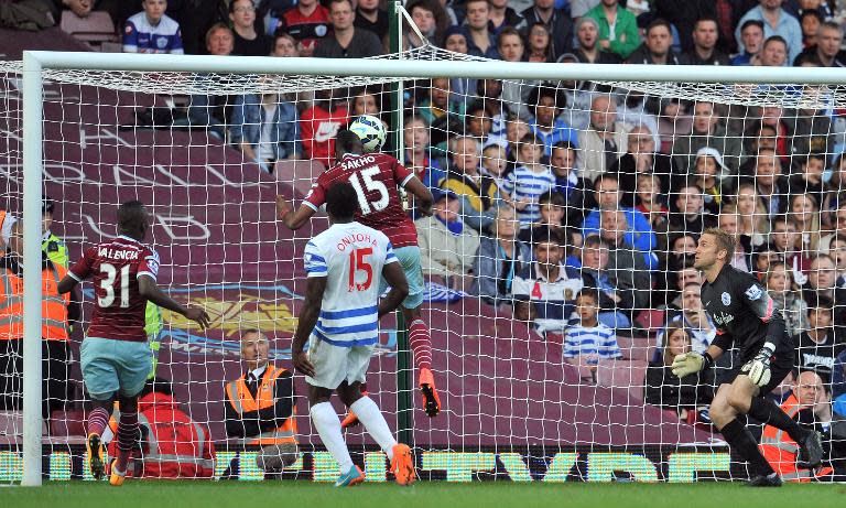 West Ham United's striker Diafra Sakho scores their second goal as Queens Park Rangers' goalkeeper Robert Green (R) looks on during the English Premier League football match on October 5, 2014