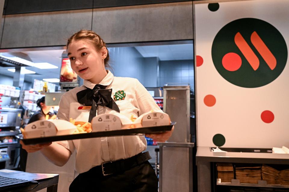 In this file photo taken on June 12, 2022 an employee holds a food order on a tray in the Russian version of a former McDonald's restaurant after the opening ceremony in Moscow.