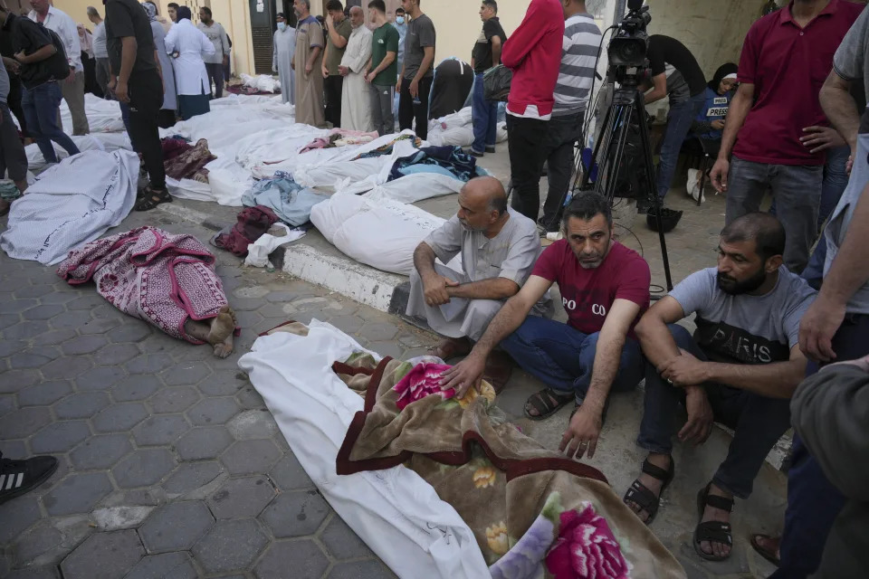 Friends and relatives stand by the bodies of Palestinians killed in the Israeli bombardment of the Gaza Strip at Al-Aqsa Hospital in Deir Al-Balah, Sunday, Oct. 22, 2023. AP Photo/Hatem Moussa)