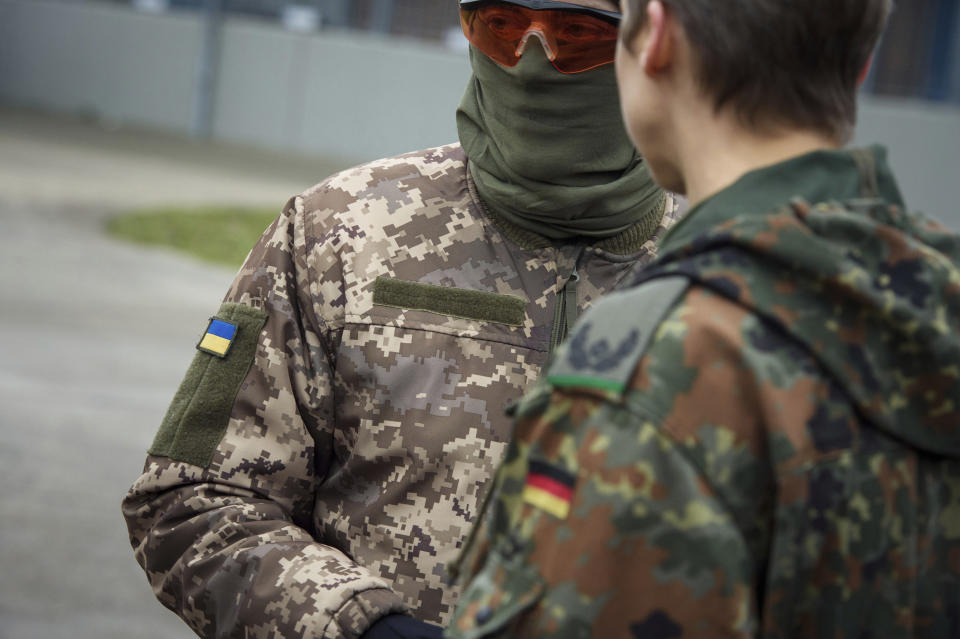 FILE - A Ukrainian soldier is talking to a German officer at the German forces Bundeswehr training area in Munster, Germany, Monday, Feb. 20, 2023. Germany said Saturday, May 13, 2023, it is providing Ukraine with additional military aid worth more than 2.7 billion euros ($3 billion), including tanks, anti-aircraft systems and ammunition. The announcement Saturday came as preparations were underway in Berlin for a possible first visit to Germany by Ukrainian President Volodymyr Zelenskyy since Russia invaded his country last year. (AP Photo/Gregor Fischer, File)