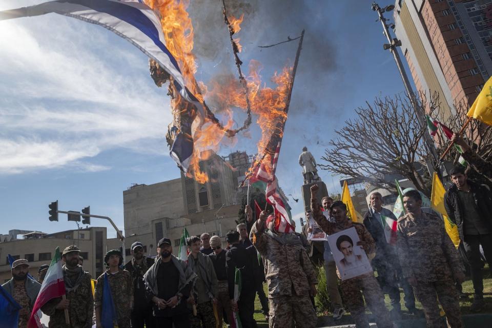 Flames emerge from flags being held by protestors.