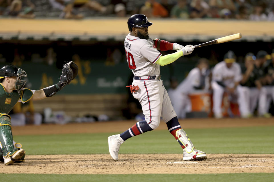 Atlanta Braves' Marcell Ozuna, right, hits a two-run single in front of Oakland Athletics catcher Sean Murphy, left, during the fifth inning of a baseball game in Oakland, Calif., Tuesday, Sept. 6, 2022. (AP Photo/Jed Jacobsohn)