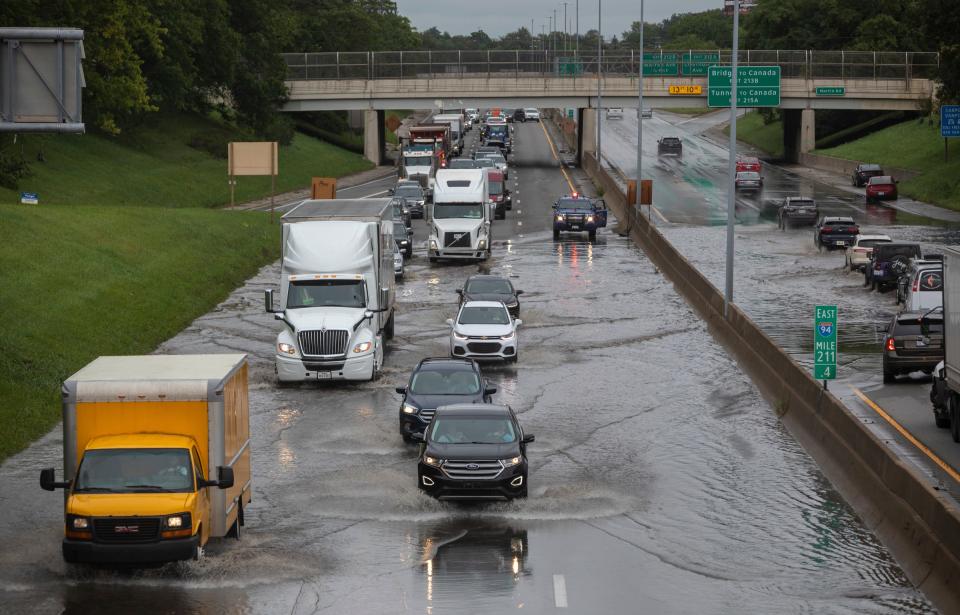 Dozens of vehicles drive through a flooded section of Interstate 94 in Detroit on Friday, Aug. 25, 2023.