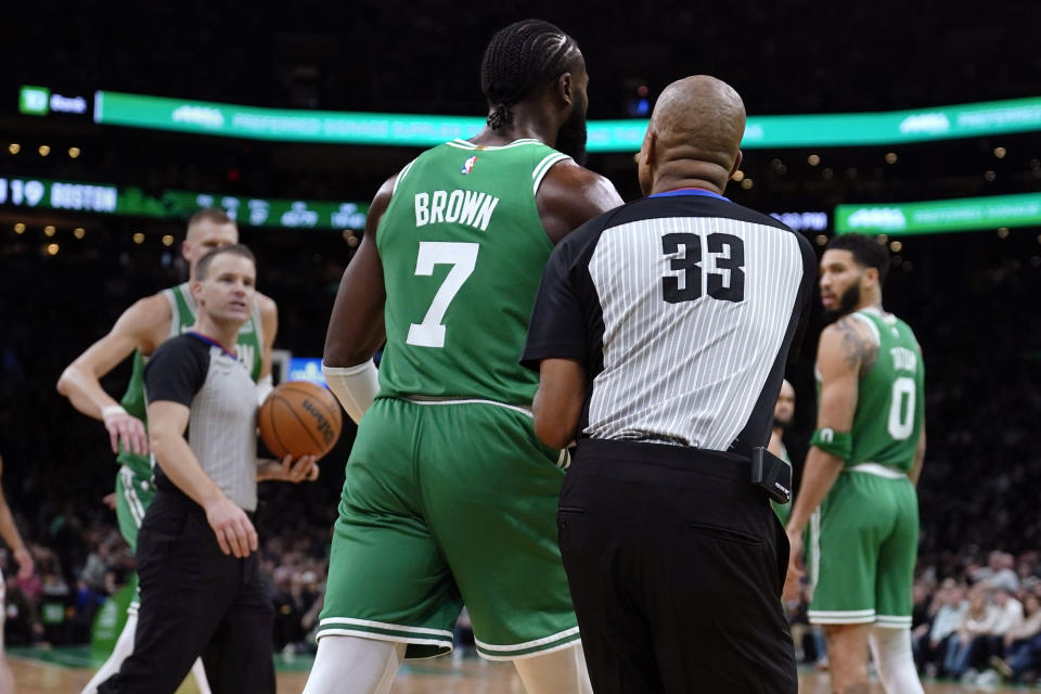Boston Celtics guard Jaylen Brown (7) is restrained by referee Sean Corbin (33) while arguing a call during the second half of an NBA basketball game, Friday, Dec. 8, 2023, in Boston. Brown was ejected after the exchange. (AP Photo/Charles Krupa)