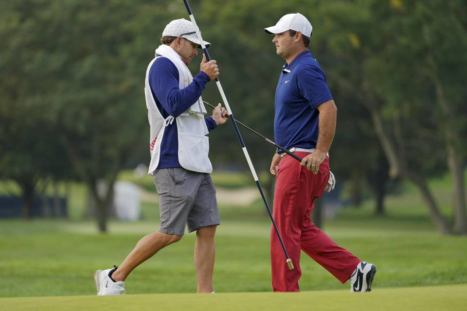 Patrick Reed, of the United States, hands his putter to his caddie during the first round of the US Open Golf Championship, Thursday, Sept. 17, 2020, in Mamaroneck, N.Y. (AP Photo/John Minchillo)