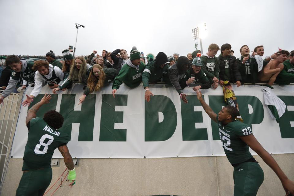 Michigan State wide receiver Jalen Nailor (8) and tight end Kameron Allen (82) high-five fans to celebrate their 37-33 win over Michigan at Spartan Stadium in East Lansing on Saturday, Oct. 30, 2021.