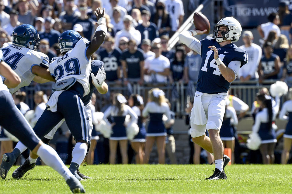 Penn State quarterback Sean Clifford (14) throws a first quarter touchdown pass to wide receiver Jahan Dotson (5) while being pressured by Villanova linebacker Amin Black (29) during an NCAA college football game in State College, Pa., on Saturday, Sept. 25, 2021. (AP Photo/Barry Reeger)