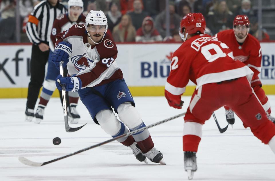 Colorado Avalanche left wing Matt Nieto (83) passes the puck past Detroit Red Wings defenseman Jordan Oesterle (82) during the second period of an NHL hockey game Saturday, March 18, 2023, in Detroit. (AP Photo/Duane Burleson)