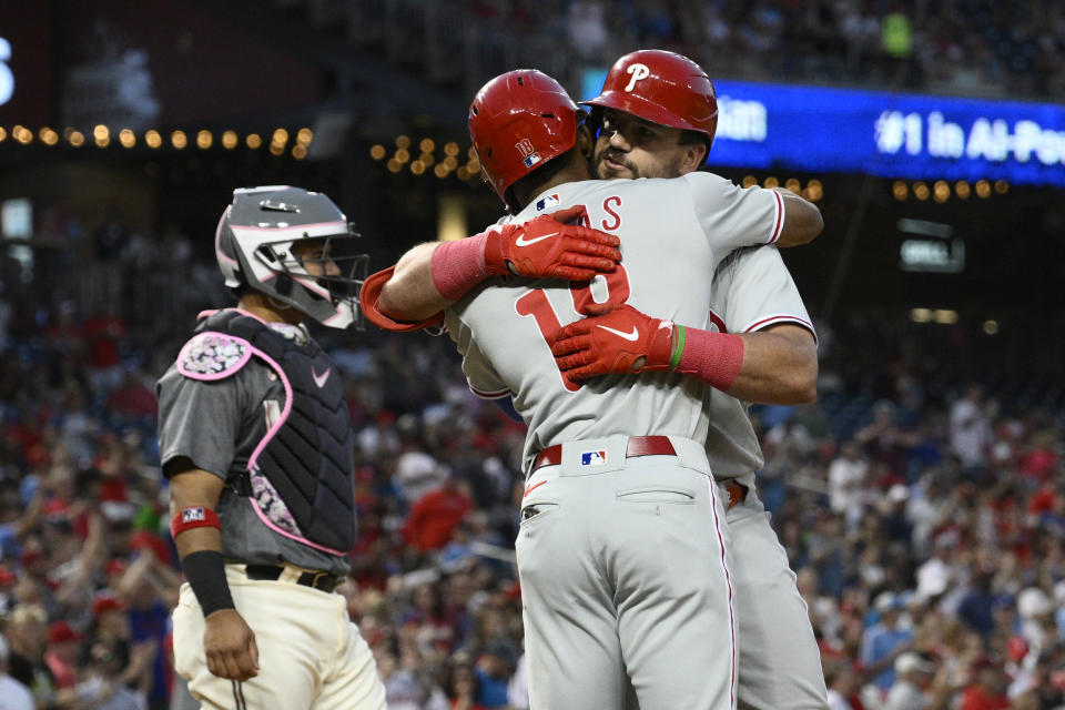Philadelphia Phillies' Kyle Schwarber, back, celebrates his two-run home run against the Washington Nationals with Johan Rojas during the fourth inning of a baseball game Friday, Aug. 18, 2023, in Washington. Nationals catcher Keibert Ruiz is at left. (AP Photo/Nick Wass)