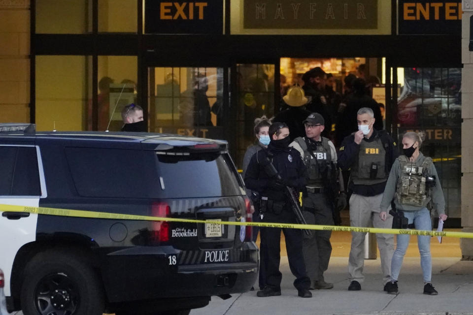 FBI officials and police stand outside the Mayfair Mall after a shooting, Friday, Nov. 20, 2020, in Wauwatosa, Wis. Multiple people were shot Friday afternoon at the mall. Wauwatosa Mayor Dennis McBride says in a statement that a suspect remains at large after the shooting at Mayfair Mall. (AP Photo/Nam Y. Huh)