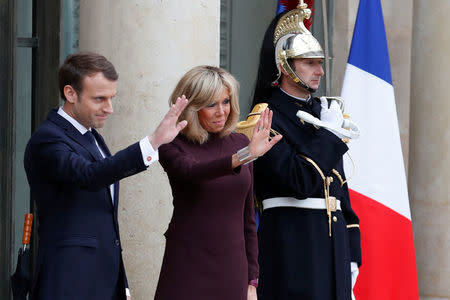 French President Emmanuel Macron and his wife Brigitte wave goodbye to their guests at the Elysee Palace in Paris, France, November 18, 2017. REUTERS/Gonzalo Fuentes