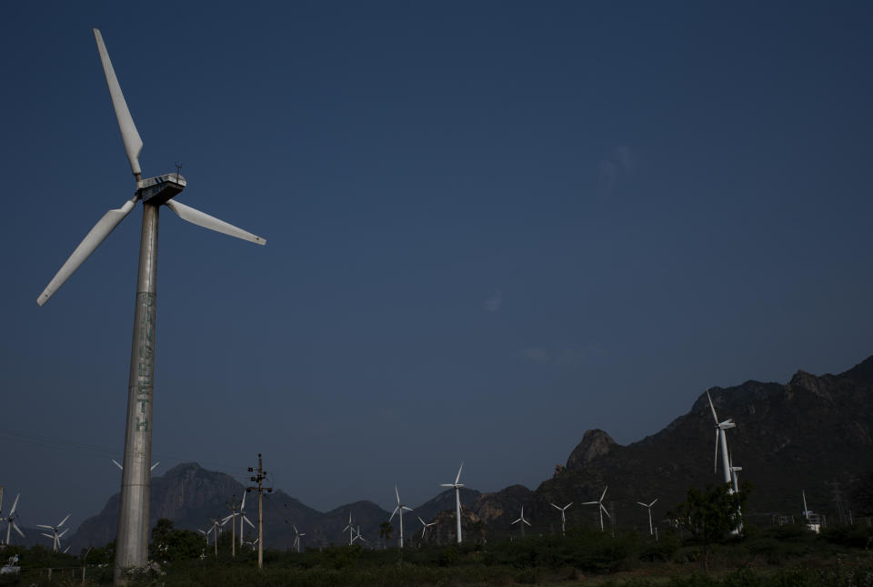 FILE - Wind turbines at one of Asia's largest wind farms work with the backdrop of Western Ghats at Aralvaimozhi, southern Tamil Nadu state, India, April 2, 2021. India will miss its renewable energy targets for the end of the year, with experts saying “multiple challenges” including a lack of financial help and taxes on imported components are stalling the clean energy industry. (AP Photo/R S Iyer, File)